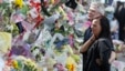 Ian Rigby (R), the stepfather of murdered British soldier Lee Rigby, and Sarah McClure look at floral tributes left at the scene of his killing in Woolwich, May 26, 2013.