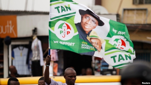 A man holds a flag in support of Nigerian President Goodluck Jonathan at a campaign rally for Lagos governorship candidate Jimi Agbaje of the People's Democratic Party in Lagos, Feb. 3, 2015.