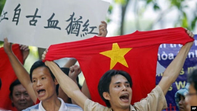 A protester holds a red T-shirt with a yellow star, representing Vietnam's national flag, while chanting anti-China slogans with other demonstrators during a rally against China's claims in the oil-rich South China Sea, in Hanoi, Vietnam, July 2011. (file