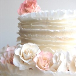 Maggie Austin innovated the frills, or ruffles, technique. The frills are created using paper-thin layers of fondant, which is a sugar paste, and are individually applied to the cake.