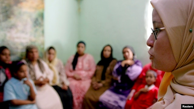 A counselor talks to a group of women to try to convince them that they should not have female genital mutilation performed on their daughters, in Minia, Egypt, Jun. 2006.