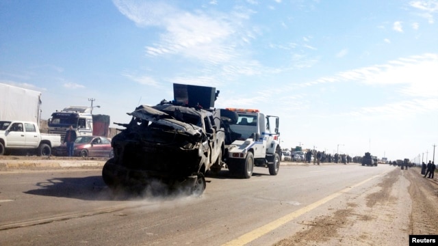 A police vehicle is towed after a suicide bomb attack in Taji, 20 km (12 miles) north of Baghdad, February 5, 2013.