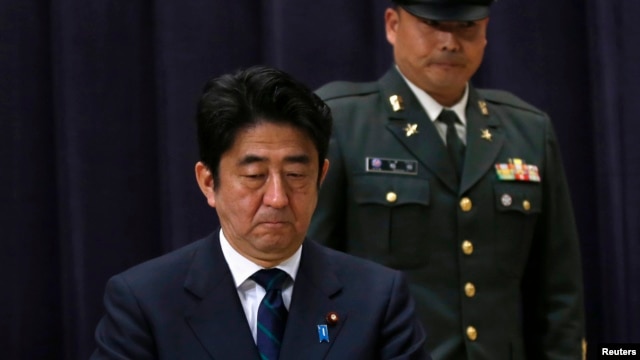 Japan's PM Shinzo Abe attends a flag return ceremony to mark the return of the Japan Self-Defense Force troops stationed with the UN Disengagement Observer Force in Golan Heights, at the Defense Ministry in Tokyo, January 20, 2013.