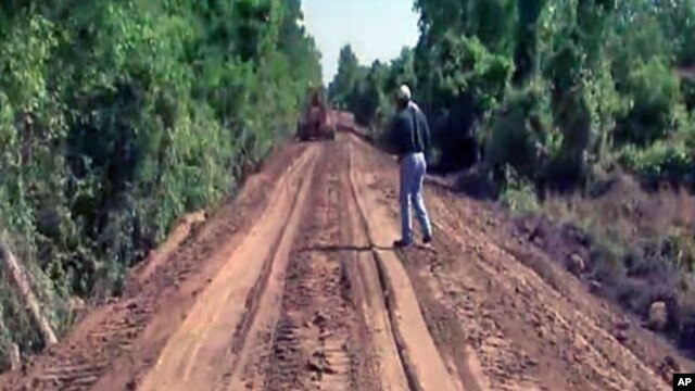 Workers push to quickly complete a makeshift levee by packing dirt on top of an old railroad bed in the Green Meadow neighborhood of South Vicksburg, Mississippi, May 2011