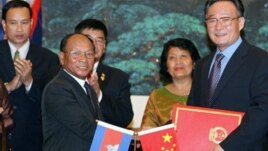 Wu Bangguo, chairman of the Standing Committee of the National People's Congress (NPC) of China, second right, and Heng Samrin, president of the Cambodian National Assembly shake hands after exchanging documents on cooperation between NPC and the Cambodia.