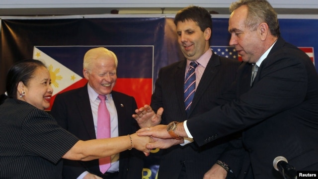 U.S. Assistant Sec. of State for East Asian and Pacific Affairs Kurt Campbell (R), U.S. Assistant Sec. of Defense for Asian and Pacific Security Affairs Mark Lippert (2nd R), Philippines ambassador to the U.S. Jose Cuisia, Philippines Foreign Affairs Undersecretary for Policy Erlinda Basilio (L)  join hands during a joint news conference in Manila, December 12, 2012. 