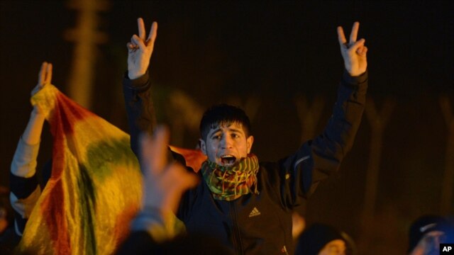 Kurds shout slogans to praise three women activists who were found shot dead in Paris, as ambulances, unseen, carry their coffins at an airport in Diyarbakir, Turkey, January 16, 2013.