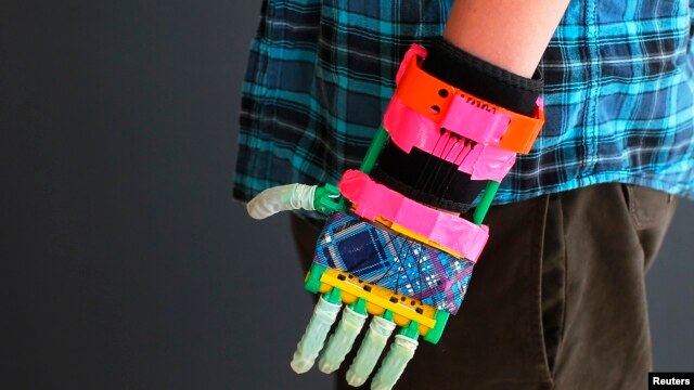 Prosthetic limbs have come a long way. Here a 12-year-old boy shows off his new, colorful, 3-D printed prosthetic hand at the new MakerBot store in Boston, Massachusetts. (Nov. 2013)