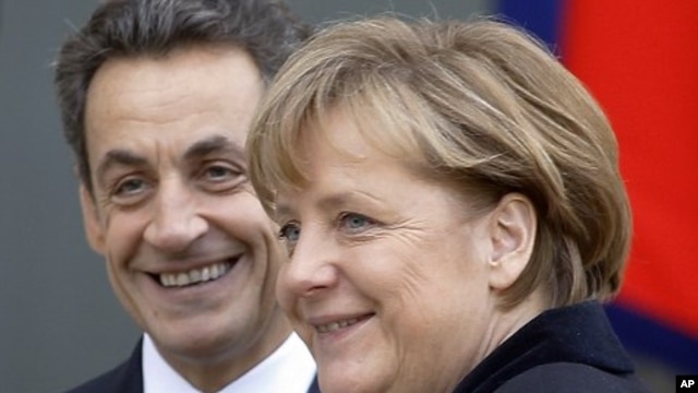 French President Nicolas Sarkozy, left, smiles as he greets German Chancellor Angela Merkel prior to their meeting at the Elysee Palace in Paris, December 5, 2011.