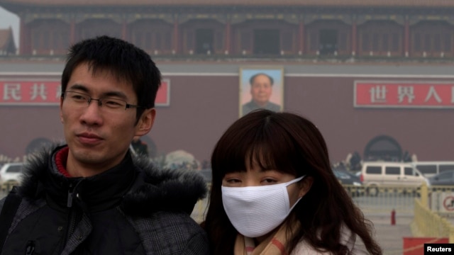 A woman wears a mask as she visits Tiananmen Square in Beijing, Jan. 13, 2013.