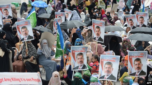 Wanawake wanaharakati wa kundi la kisiasa la kislamu Jamaat-e-Islami (JI) wanabeba picha za Mohamed Morsi wakati wa maandamano mjini Islamabad hapo August 18, 2013.    