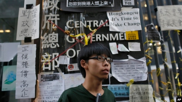 Sinh viên Joshua Wong 17 tuổi lãnh đạo phong trào xuống đường ở Hong Kong đứng trược trụ sở chính phủ sau một cuộc họp báo trong khu vực biểu tình ở trung tâm Hong Kong, 9/10/14