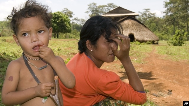 An ethnic minority Cambodian boy, left, stands next to his mother at a village in Mondul Kiri province some 265 kilometers (165 miles) northeast Phnom Penh, file photo. 