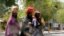Women attempt to cross Jos Road with their belongings, after the military declared a 24-hour curfew over large parts of Maiduguri in Borno State May 19, 2013.