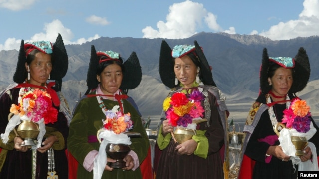 Ladakhi women, wearing 'perak', or traditional headgear, wait towelcome the Tibetan spiritual leader Dalai Lama outside a Buddhisttemple near Leh, capital of the Ladakh region in the troubled northernIndian state of Jammu and Kashmir August 23, 2002.(file