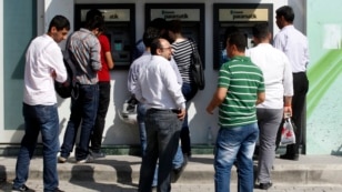People line in front of automated teller machines in Hatay, Turkey, May 17, 2013.