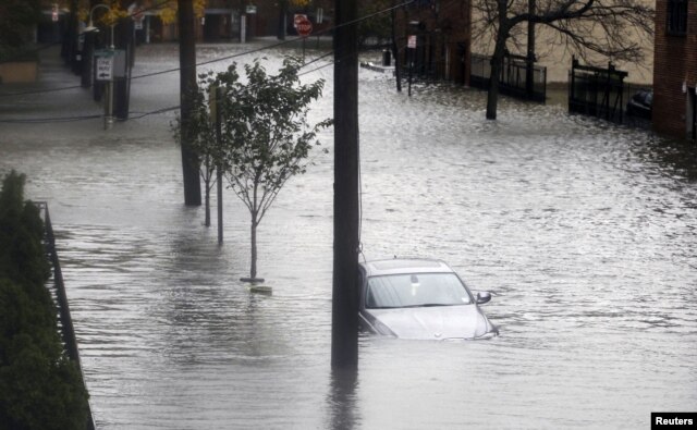 Floodwaters surround a car parked on a street in Hoboken, New Jersey, October 30, 2012, after Sandy, one of the biggest storms ever to hit the United States, roared ashore with fierce winds and heavy rain near Atlantic City.