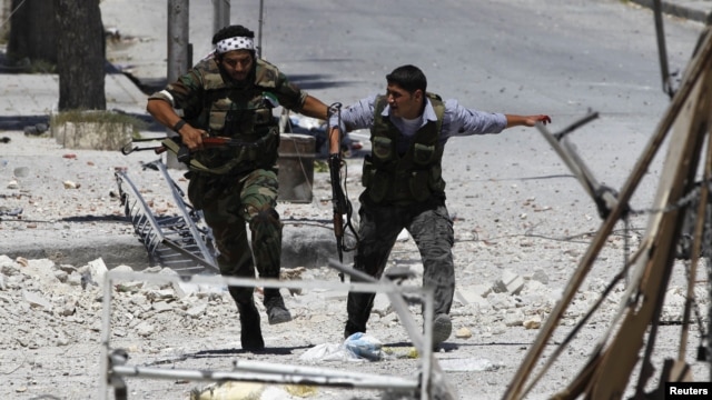 Free Syrian Army fighters run to take cover away from the exchange fire while fighting with regime forces in the Seif El Dawla neighbourhood of Syria's south west city of Aleppo, August 24, 2012. 