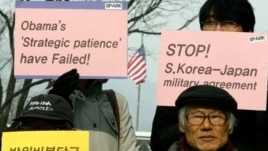 Protesters hold placards during denouncing military alliance between South Korea, the United States and Japan, Seoul, Jan. 15, 2013.
