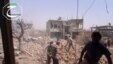 In this May 18, 2013 citizen journalism image provided by Qusair Lens which has been authenticated based on its contents and other AP reporting, shows Syrians inspecting the rubble of damaged buildings due to government airstrikes, in Qusair, Homs province, Syria.