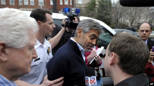 Actor George Clooney, center, and Rep. Jim Moran, D-Va., left, are led to a police vehicle after being arrested during a protest at the Sudan Embassy in Washington,  March 16, 2012. 