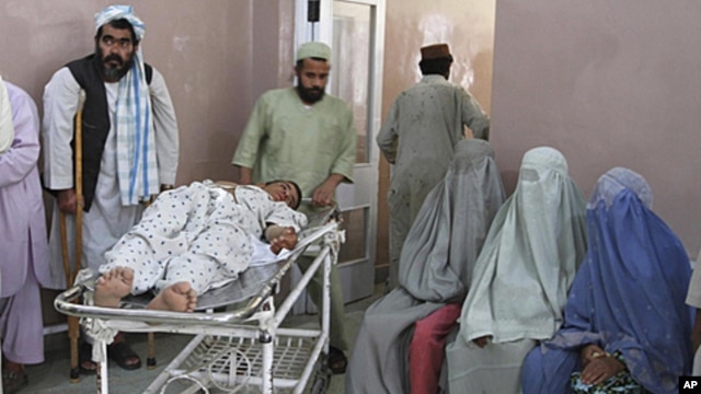 A wounded man is transported at a hospital after a roadside bomb blast in the Panjwai district of Kandahar May 24, 2011