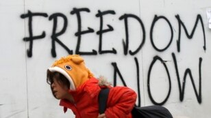A girl walks by a grafitti at the train station near the makeshift refugee camp at the northern Greek border point of Idomeni, Greece, March 29, 2016. 