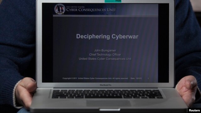 FILE - A cyber warfare expert who is chief technology officer of the U.S. Cyber Consequences Unit, a non-profit group that studies the impact of cyber threats, holds a notebook computer while posing for a portrait.