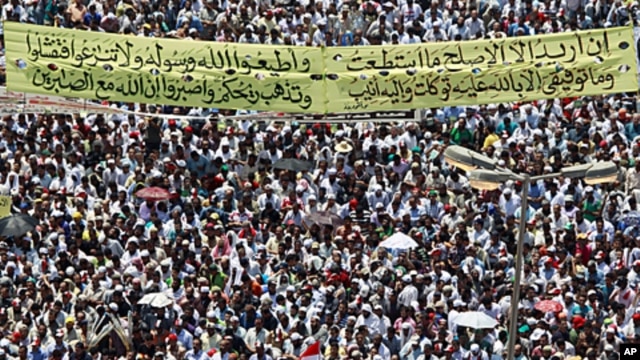 Protesters gather with a banner with a Koranic verse in Tahrir square in Cairo, July 29, 2011