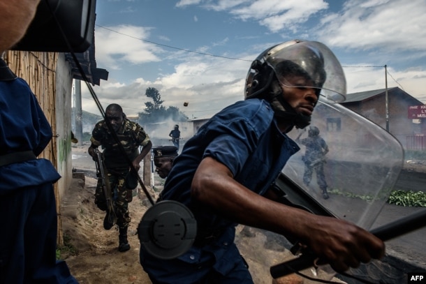 FILE - Burundi's policemen and army forces run after protesters against incumbent president Pierre Nkurunziza's bid for a 3rd term on 13 May 2015 in Bujumbura, May 13, 2015.