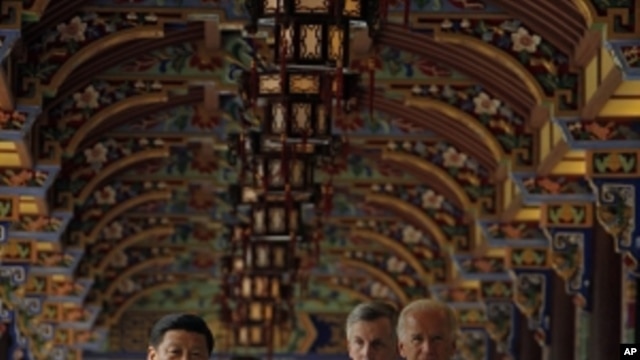 U.S. Vice President Joe Biden, right, walks with Chinese Vice President Xi Jinping, left, as they visit the South Bridge in Dujiangyan on the outskirts of Chengdu, in southwestern China's Sichuan province, Sunday, Aug. 21, 2011