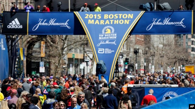 Corredores y espectadores se reunen en la líne de llegada del maratón de Boston, en la víspera de la competencia.