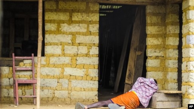In this Tuesday, Oct. 21, 2014 file photo, a man suffering from the Ebola virus lies on the floor outside a house in Port Loko Community, on the outskirts of Freetown, in Sierra Leone.
