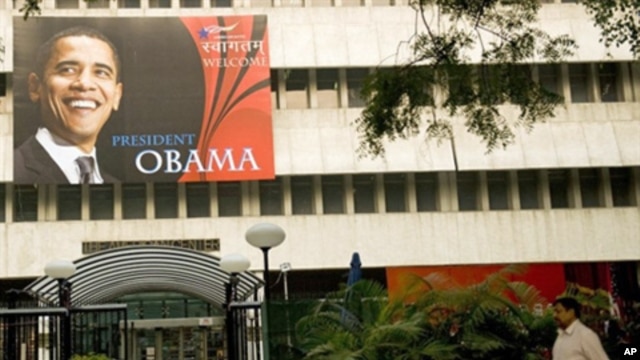 An Indian pedestrian walks past a billboard welcoming US President Barack Obama outside The American Centre in New Delhi, 04 Nov. 2010.