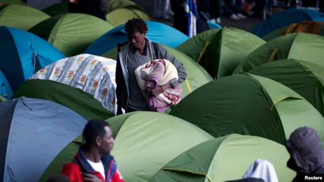 Socijalni radnici evakuišu migrante iz kampa koji su podigli ispod mosta Šarl Degol na Seni, u Parizu, 17. septembra 2015.