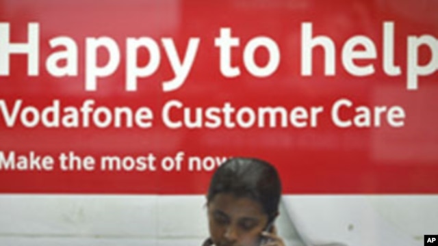 An employee talks on mobile phone inside a Vodafone store in Agartala, capital of India's northeastern state of Tripura, January 20, 2012. 