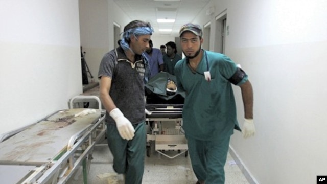Body of a NTC fighter is wheeled into a hospital after an ambush by pro-Gaddafi forces in Ras Lanuf on September 12, 2011.