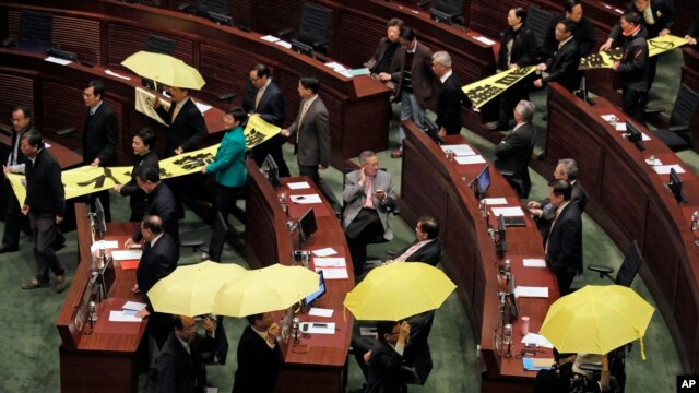 Các nhà lập pháp thân dân chủ giương dù vàng và bỏ ra ngoài trong lúc Trưởng quan hành chính Hồng Kông Lương Chấn Anh đọc diễn văn, ngày 14/1/2014.