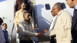 Jordanian peacekeepers Hasan Al-Mazawdeh (front) and Qasim Al-Sarhan are welcomed by officials as they arrive at Khartoum Airport, January 2, 2013, after 136 days of captivity in Sudan's Darfur region according to local media.