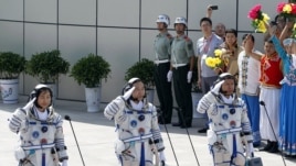 China's astronauts from left Liu Yang, Jing Haipeng and Liu Wang salute before they depart for the Shenzhou 9 spacecraft rocket launch pad at the Jiuquan Satellite Launch Center in Jiuquan, China, Saturday, June 16, 2012.