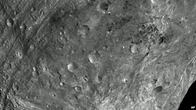 In this image, obtained by Dawn's framing camera, a peak at Vesta's south pole is seen at the lower right. The grooves in the equatorial region are about 10 kilometers wide. The image was taken on July 24, 2011, from a distance of about  5,200 kilometers