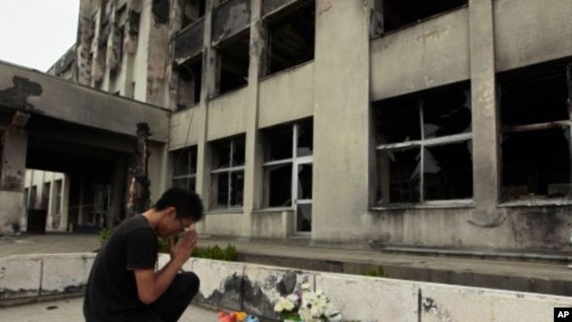 Yuki Omori, 23, prays at a makeshift shrine at Kadowaki Elementary School in Ishinomaki, northeastern Japan, September 11, 2011, six months after the March 11 earthquake.