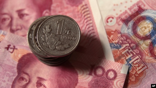Chinese one-yuan coins placed on 100-yuan banknotes, Dec. 30, 2010 (file photo).