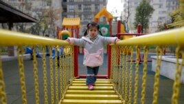 A child walks on a swinging bridge at a kindergarten in Wuhan, Hubei province, December 3, 2012.