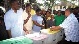 The returning officer for Mvita Constituency, Mombasa,  Gabriel Mwalenga, right, explains to registered voters how the ballot boxes will be used in the forthcoming general elections during an election mock voting exercise.