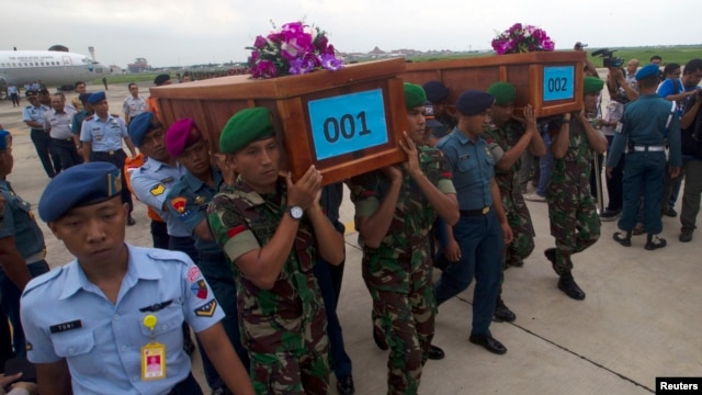 Quân đội Indonesia khiêng quan tài chứa thi thể của hai nạn nhân vụ rớt máy bay của hãng AirAsia tại một căn cứ quân sự ở Surabaya, ngày 31/12/2014.