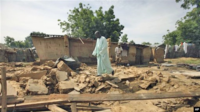 Rabiu Wada walks on the remains of his home, destroyed by flooding, in the village of Rimgim, near Dutse in northern Nigeria, 28 Sep 2010