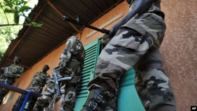 Soldiers stand guard outside the office of Salou Djibo, leader of the coup that overthrew Niger's president Mamadou Tandja in Niamey, 21 Feb 2010