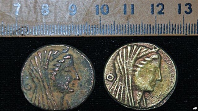 An undated handout picture released by Egypt's Supreme Council of Antiquities shows two coins dating back to the era of Ptolemy III 222-246 BC, discovered in an Egyptian oasis, south of the capital Cairo, 22 Apr 2010
