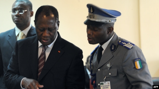 Ivory Coast's President Alassane Ouattara (L) uses an ipad prior to attending African Union talks in Addis Ababa, March 10, 2012.
